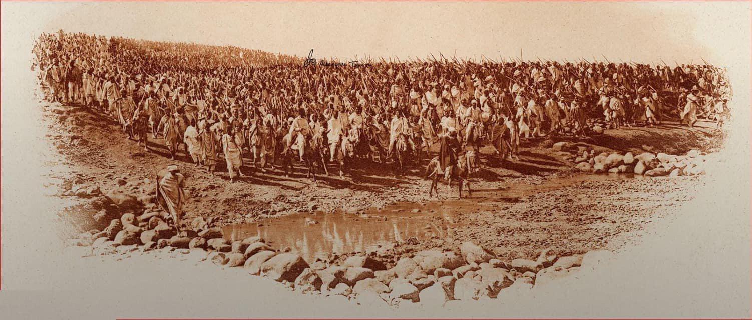 Emperor Menelik II stands before a vast formation of Ethiopian troops gathered in the field.
