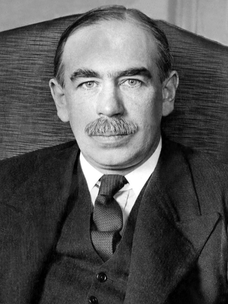 Economist John Maynard Keynes sits at a desk in his London home.