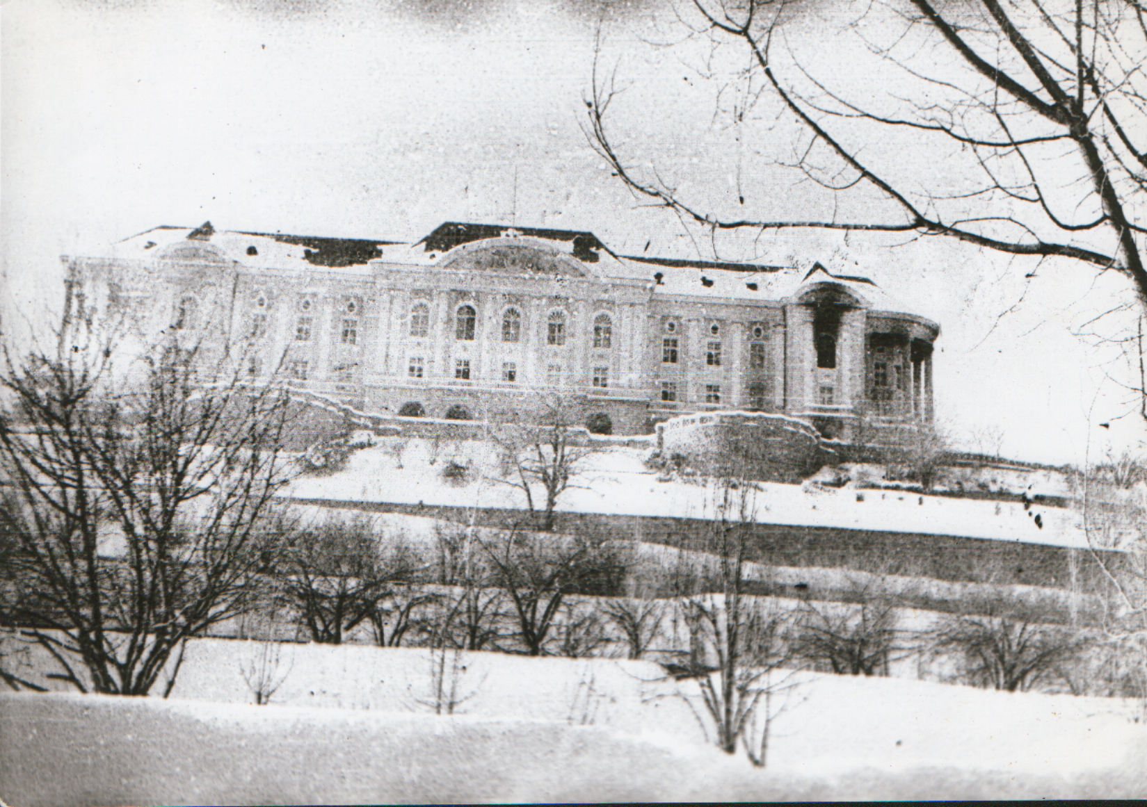 The damaged Tajbeg Palace stands on a snowy hill with broken roof sections visible above bare trees.