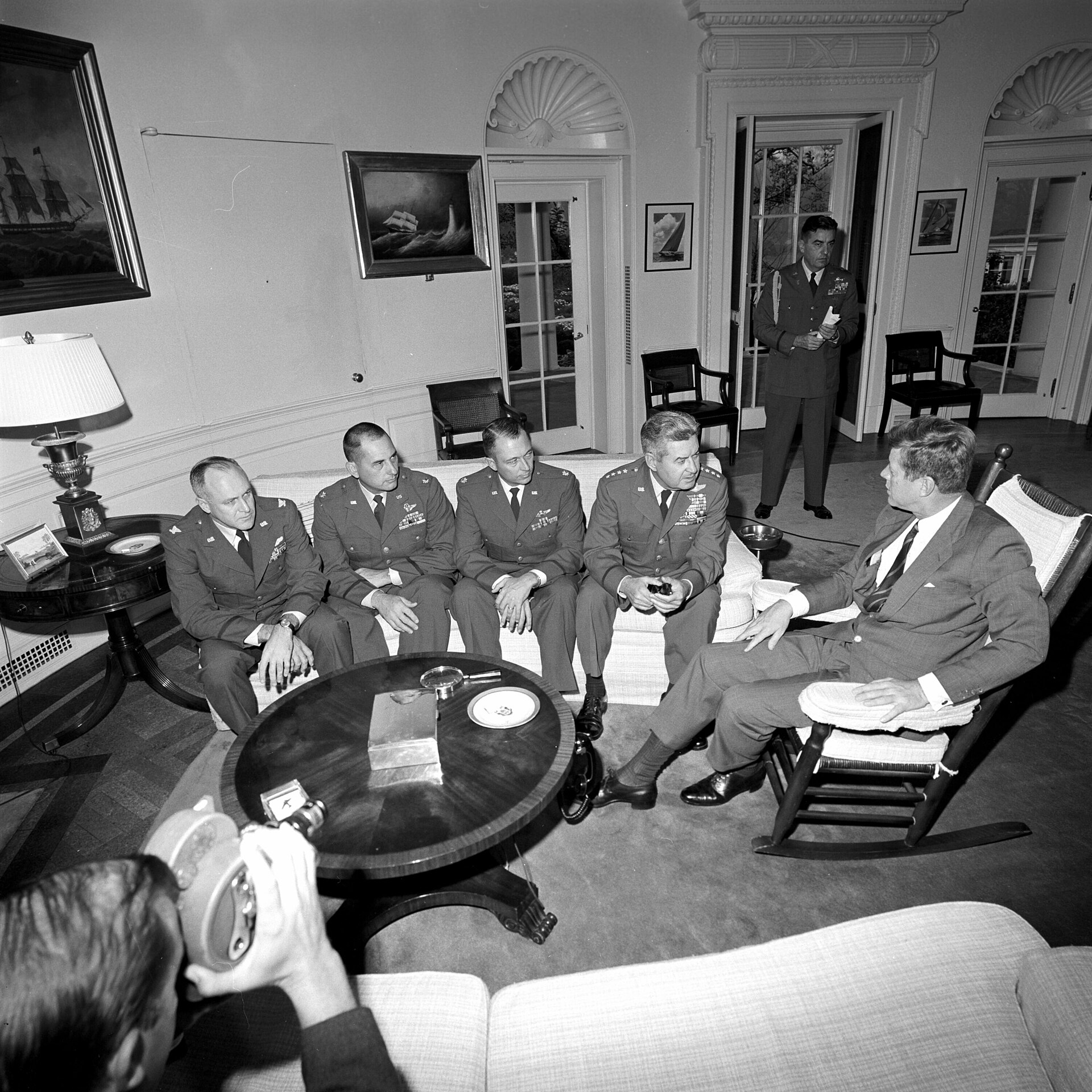 President Kennedy sits with Air Force reconnaissance officers and General Curtis LeMay in the Oval Office.
