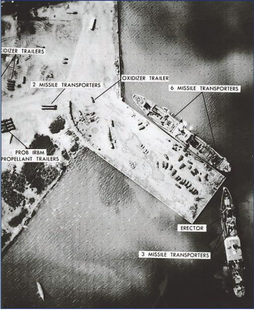 Covered Soviet missile equipment is loaded onto a cargo ship at a Cuban port for return to the Soviet Union.