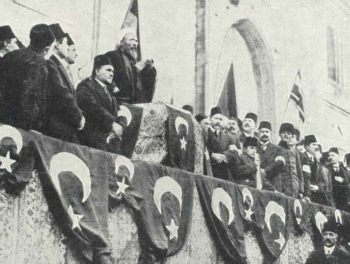 An Ottoman religious official addresses a dense public gathering from a raised platform.
