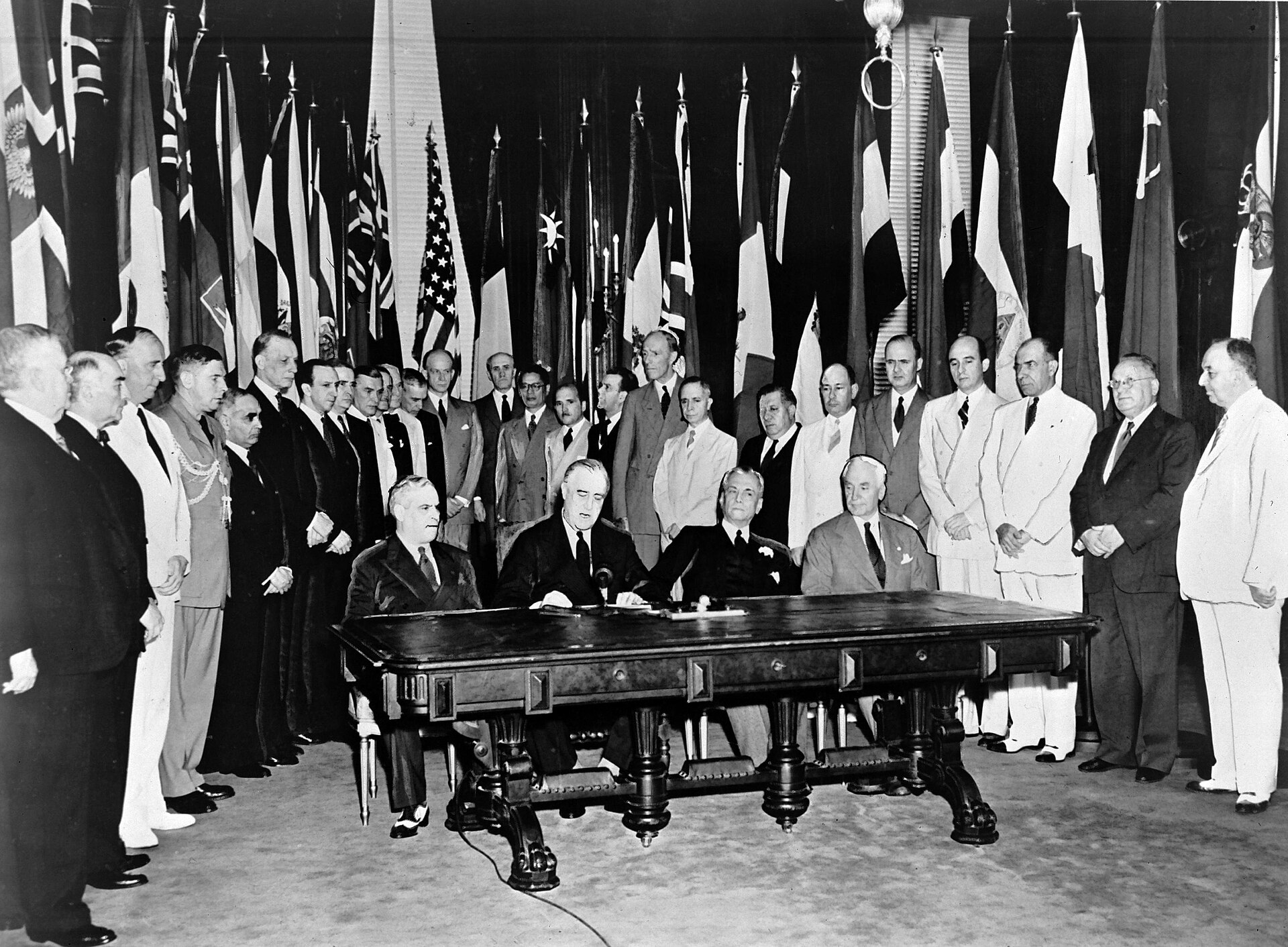 Representatives gather around a desk as the Declaration by United Nations is signed in Washington in 1942.
