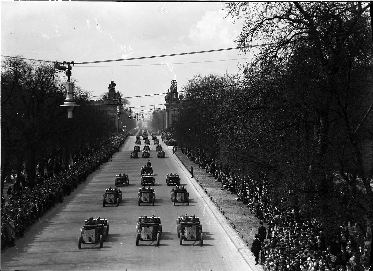 A German Wehrmacht anti-tank column passes spectators during a military parade on a Berlin street in 1936.