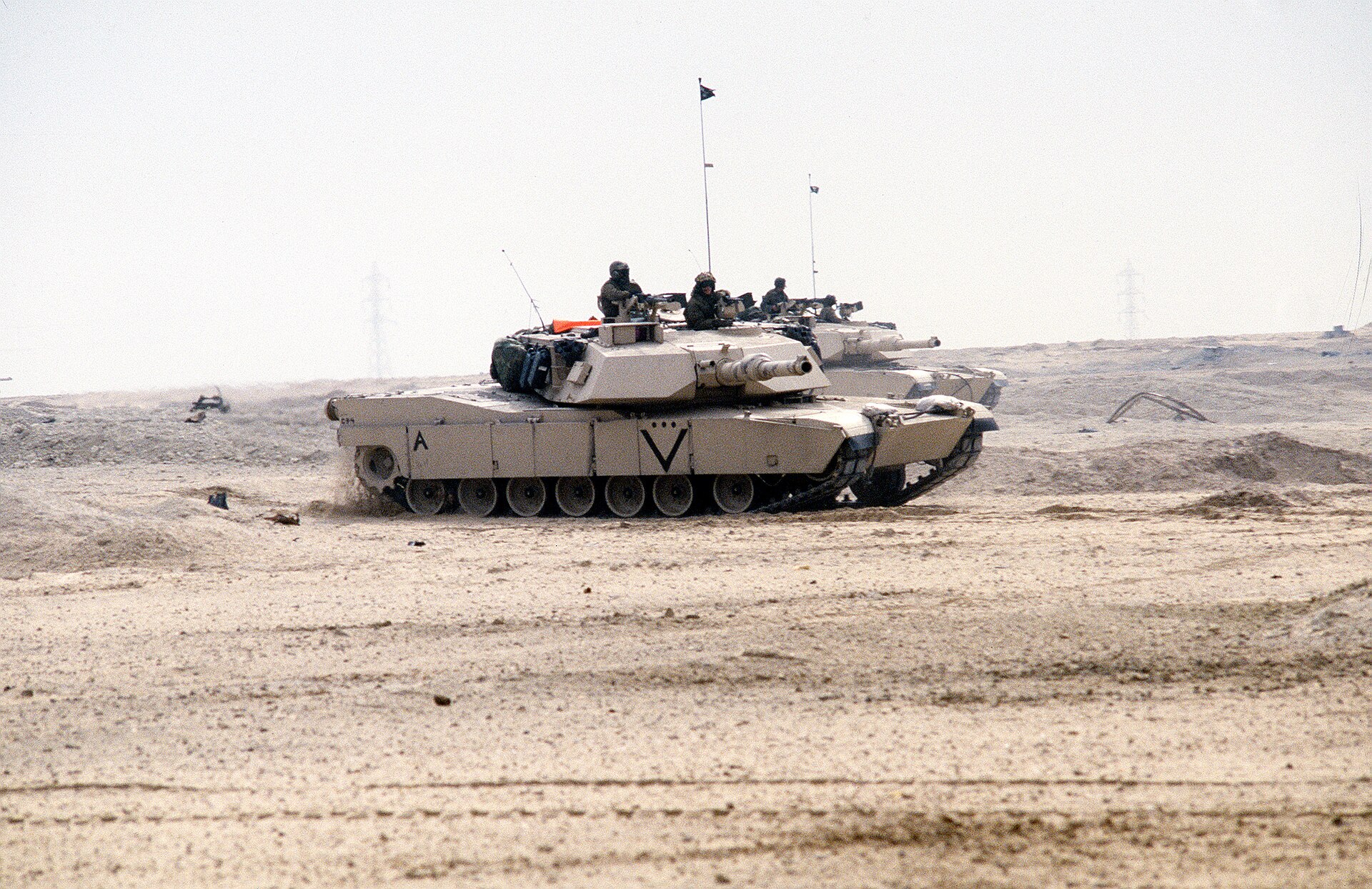 Two United States Marine Corps M1A1 Abrams tanks advance across the desert during the ground offensive.