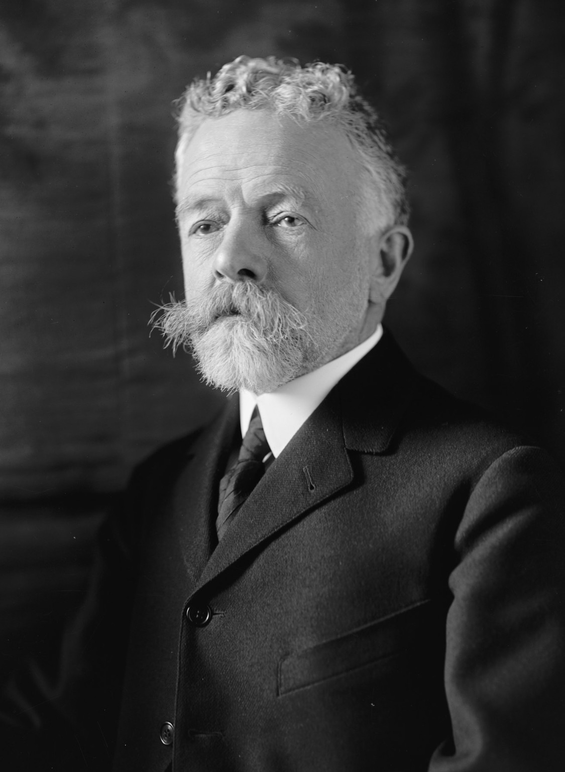A portrait photograph of Senator Henry Cabot Lodge, bearded, in a dark suit.