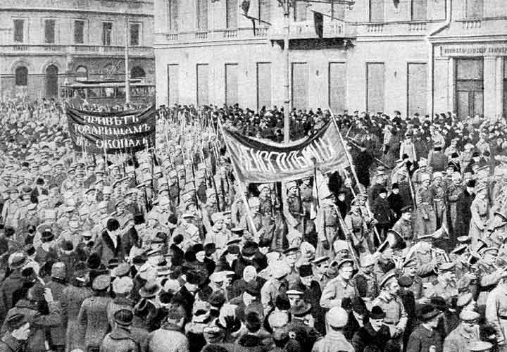 A large group of armed soldiers and civilians fills a Petrograd street during the February Revolution.