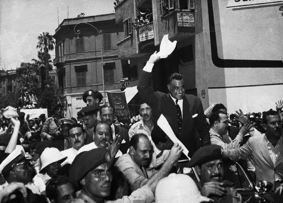 Gamal Abdel Nasser smiles above a tightly packed crowd of cheering supporters in Cairo in 1956.