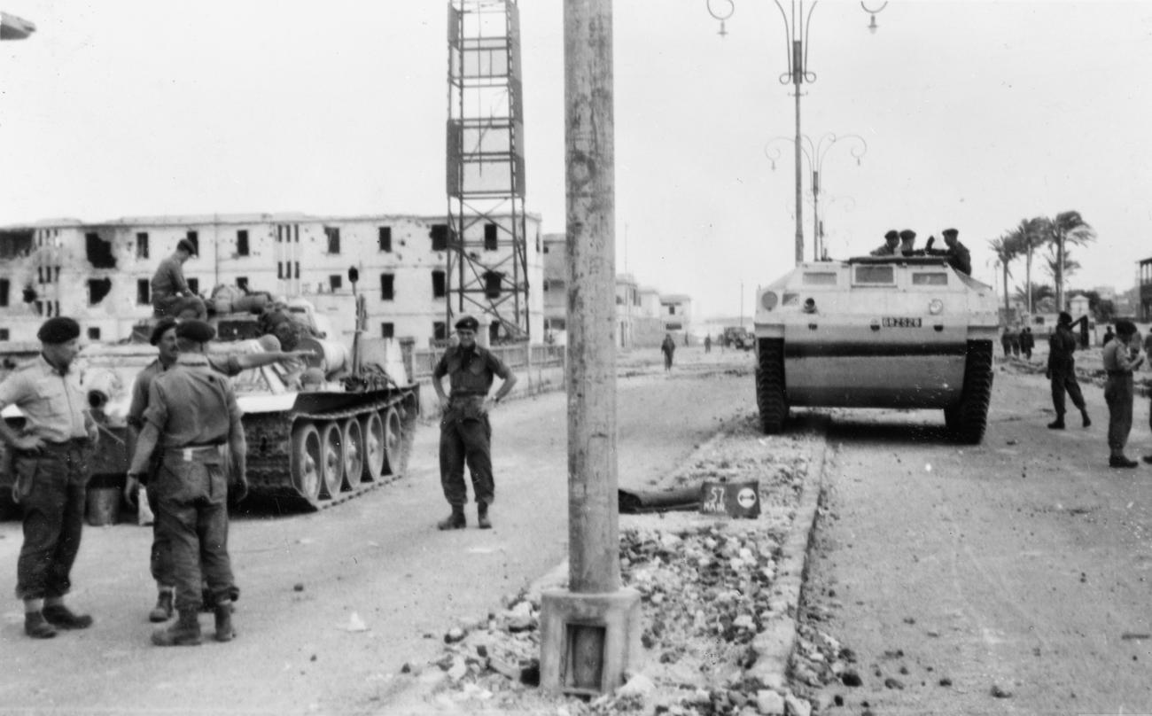 British paratroopers and commandos stand with armored vehicles at the Coast Guard barracks in Port Said.